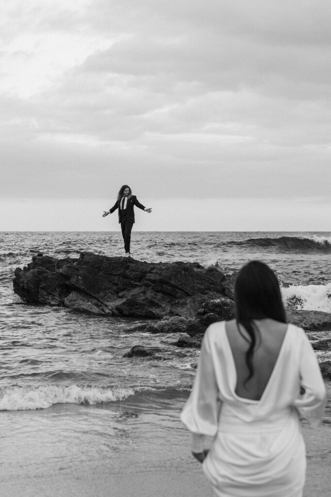 Destination wedding couple framed by dramatic coastal scenery